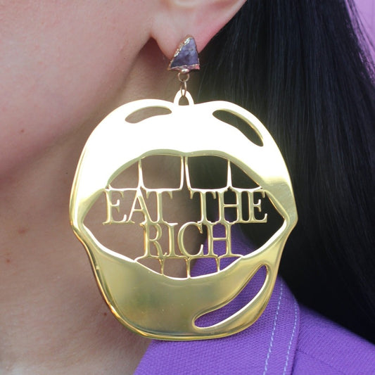 18K Gold Statement Earrings shaped as a mouth with the words "Eat The Rich" between the top and bottom row of teeth featuring Amethyst rough cut crystals